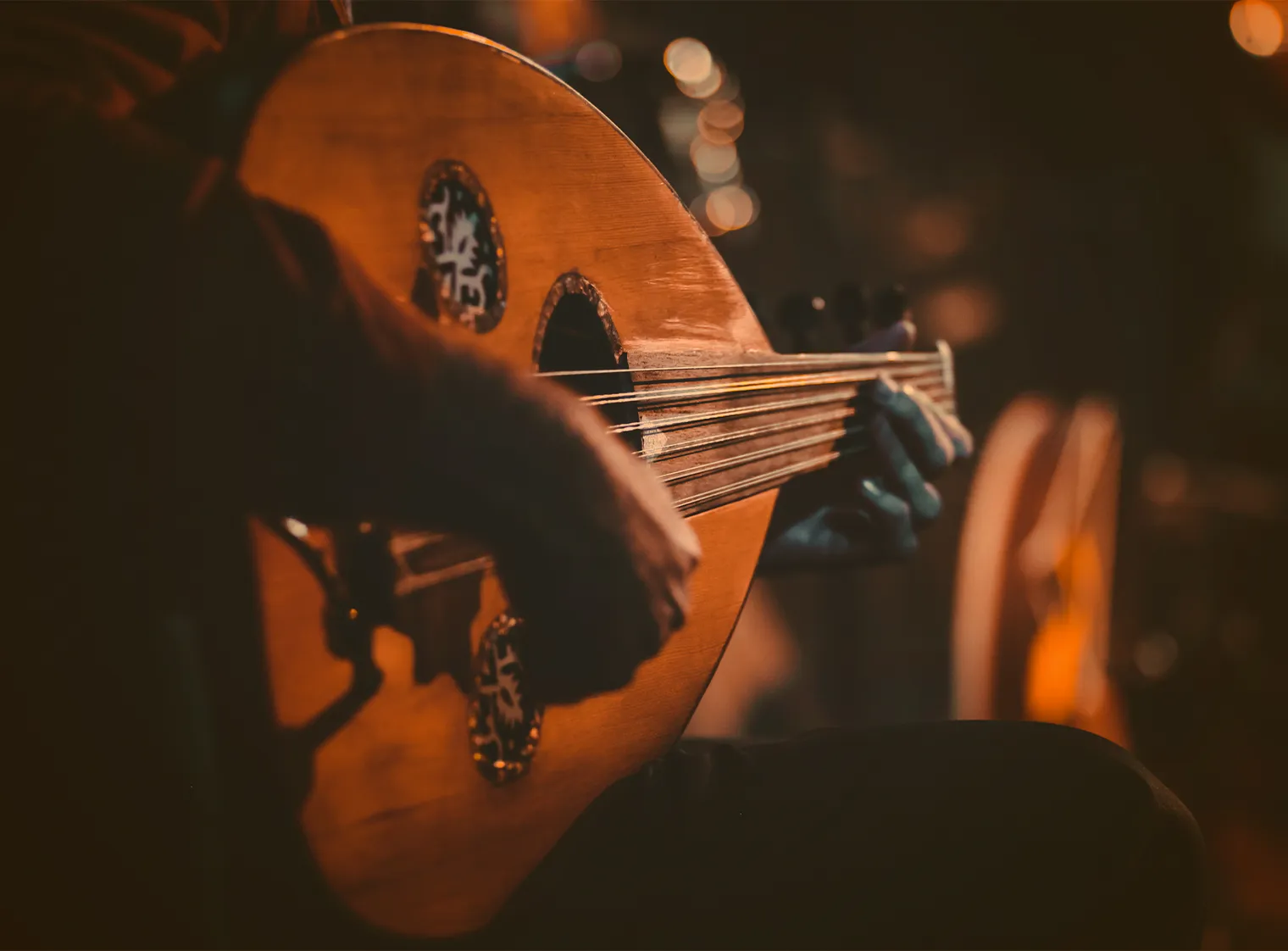 Gros plan sur un musicien jouant du oud.