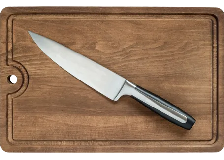 Un couteau de cuisine posé sur une planche à découper en bois.