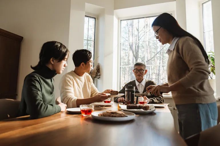 Une famille asiatique se réunit dans une salle à manger pour partager un repas.